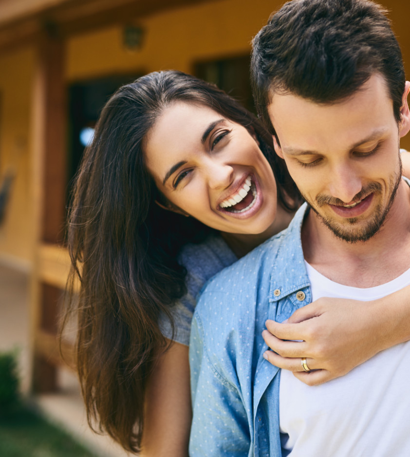 Hes the love of my life. Cropped portrait of an affectionate young couple standing outside with their house in the background. couples preconception photo