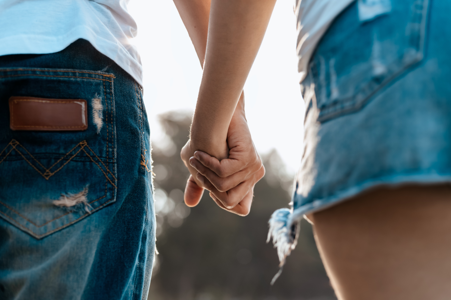 Romantic couple holding hands and walking on beach. Man and woma photo of couple working on preconception health