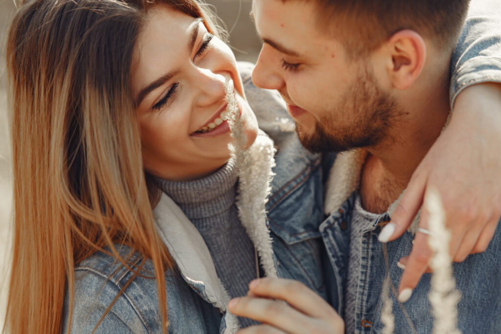 Cute couple in a jeans clothes in a spring field Photo of couple preparing for pregnancy