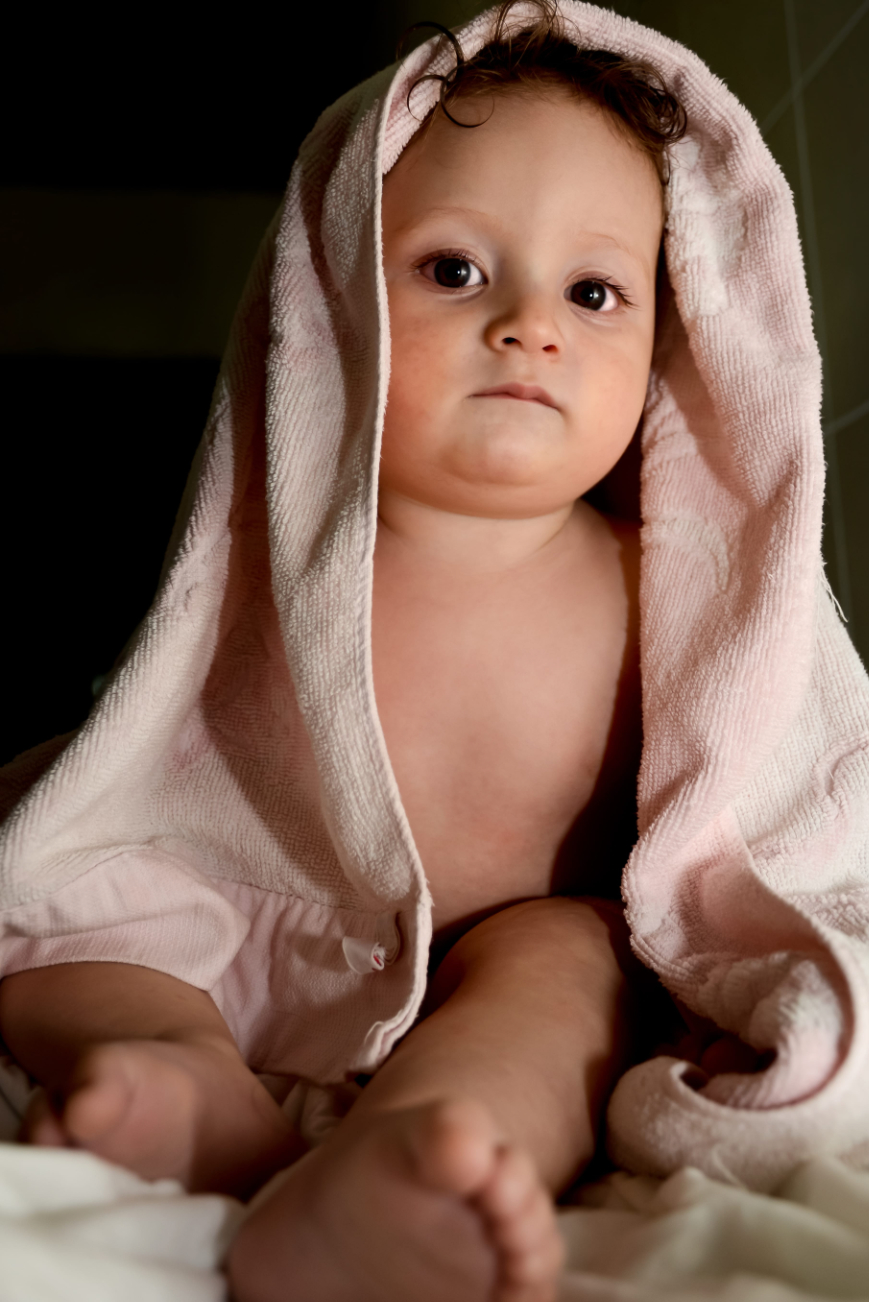 Baby after bath wrapped in a soft cloth with a relaxed expression Baby after bath wrapped in a soft cloth with a relaxed expression