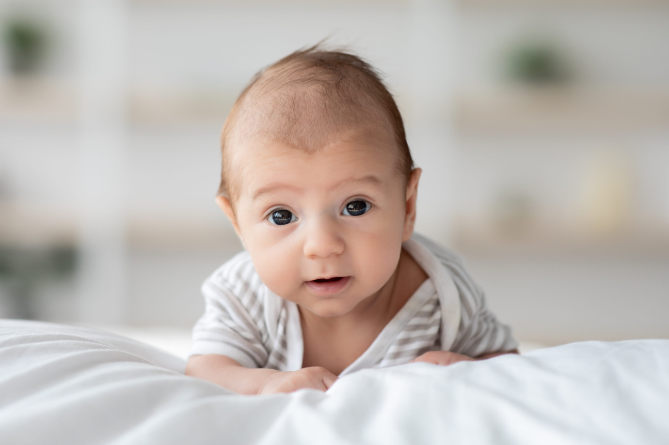 Cute Little Infant Child Lying On His Belly On Bed At Home New Baby happy after chiropractic care photo