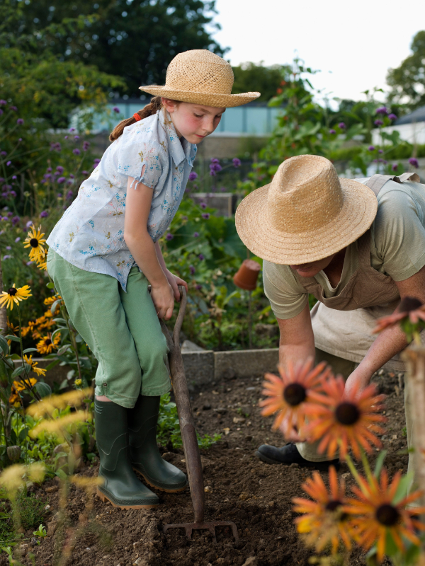 A young girl and woman work in allotment photo of gardening with the grandkids