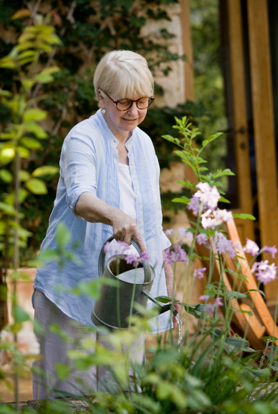 Mature woman watering her garden photo of watering the flowers