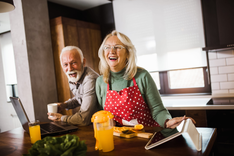 Senior couple enjoying while preparing lunch together in the kitchen Middle aged couple having fun making dinner